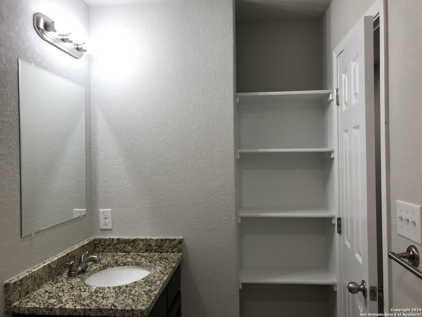 16905 Spirit Brook, Unit 2 Selma, TX 78154 - Photo 13 of 15 a bathroom with a granite countertop sink and a mirror