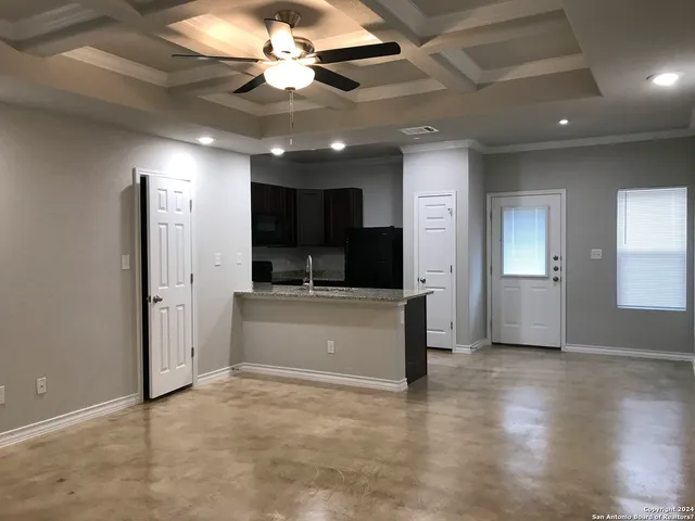 a view of a livingroom with kitchen and a window