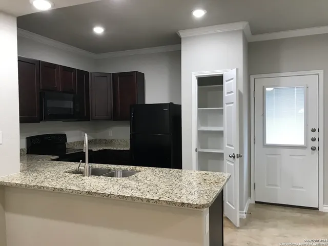 a kitchen with granite countertop a refrigerator and a sink