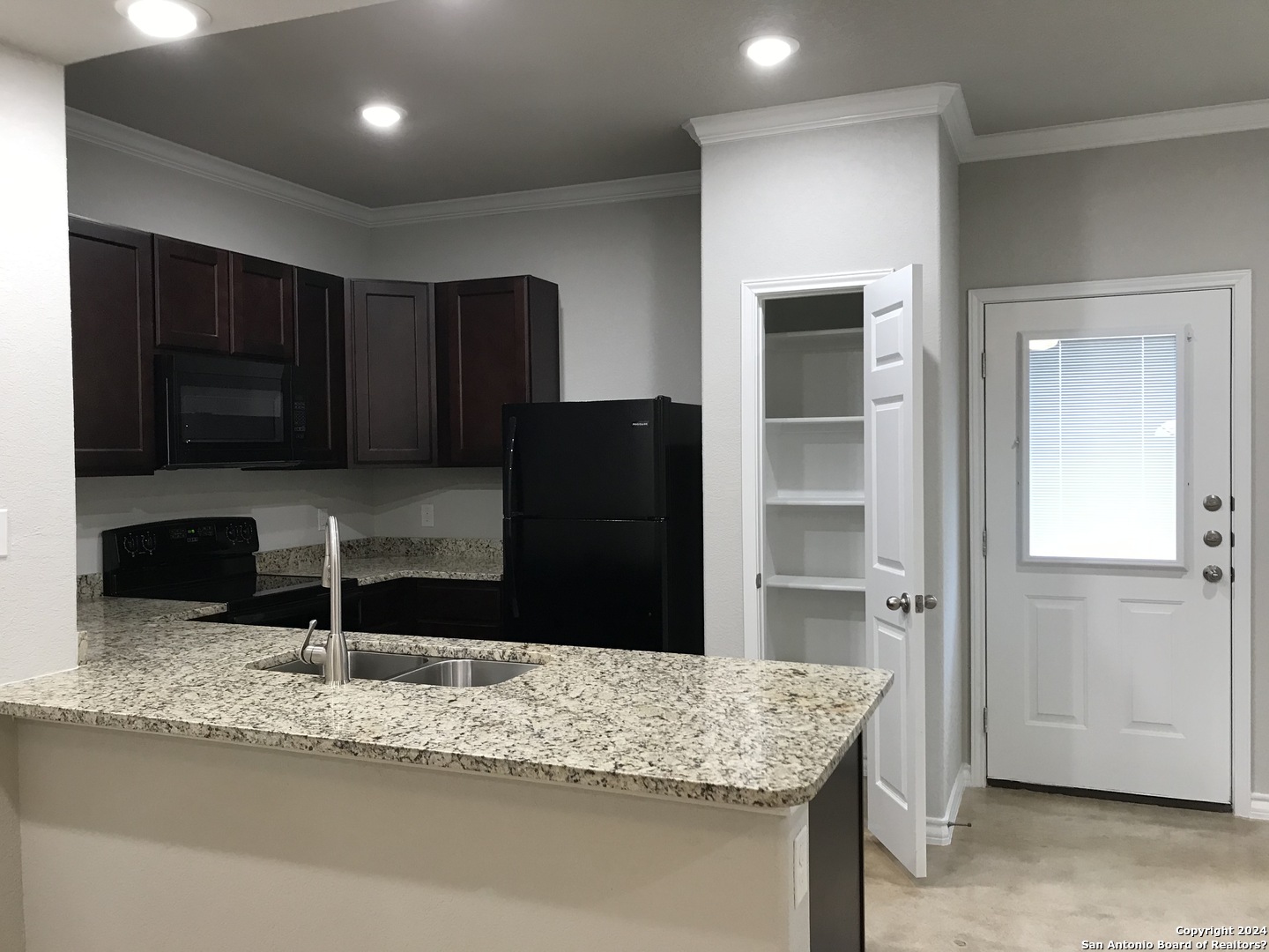 16905 Spirit Brook, Unit 2 Selma, TX 78154 - Photo 4 of 15 a kitchen with granite countertop a refrigerator and a sink