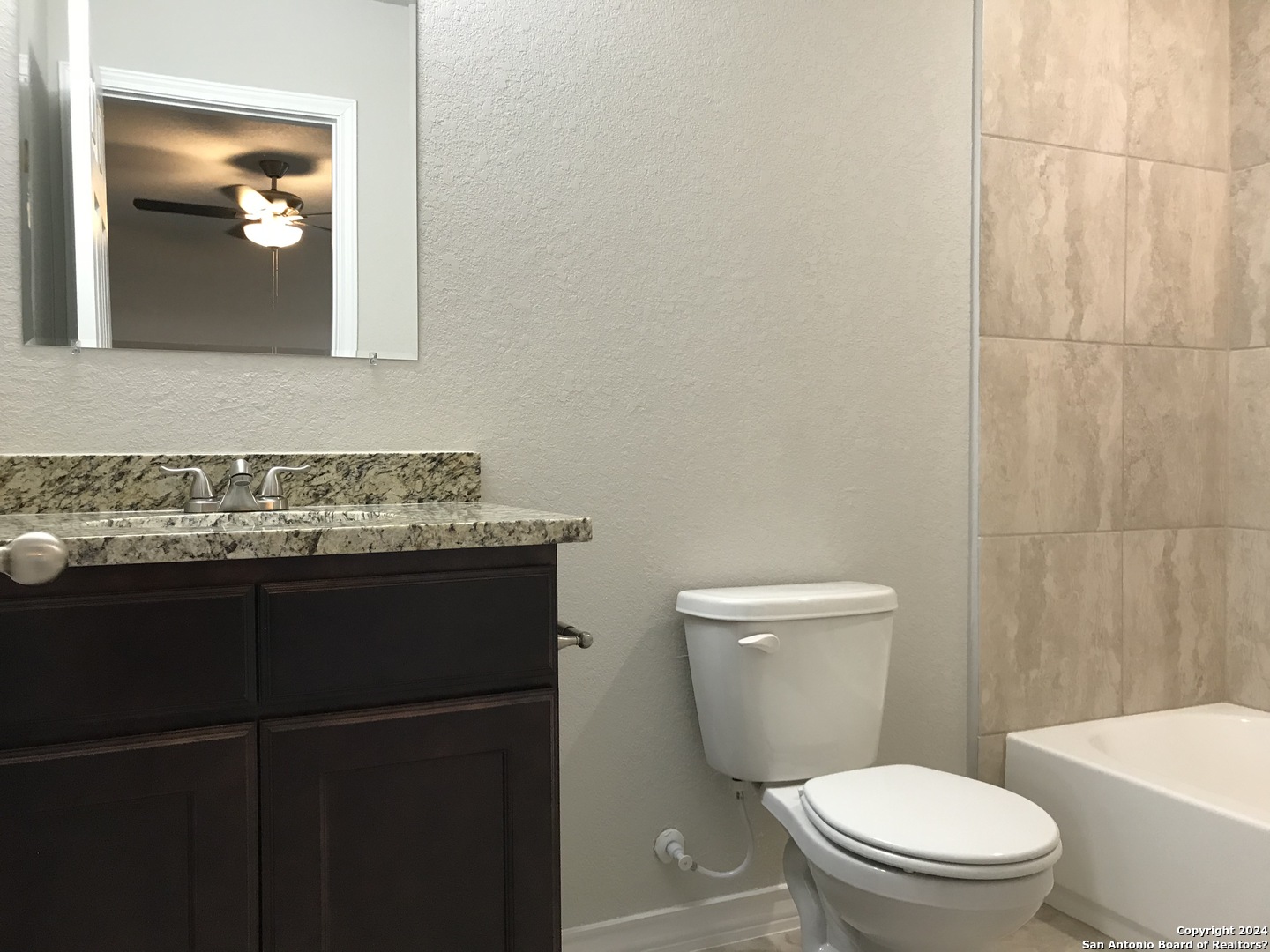 16905 Spirit Brook, Unit 2 Selma, TX 78154 - Photo 8 of 15 a bathroom with a granite countertop toilet sink and mirror