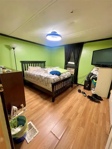 a bedroom with bed and a flat screen tv