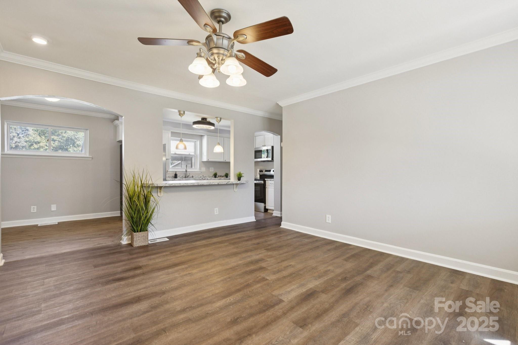1024 Old Mountain View Road Mount Holly, NC 28120 - Photo 14 of 41 an empty room with wooden floor a ceiling fan and windows