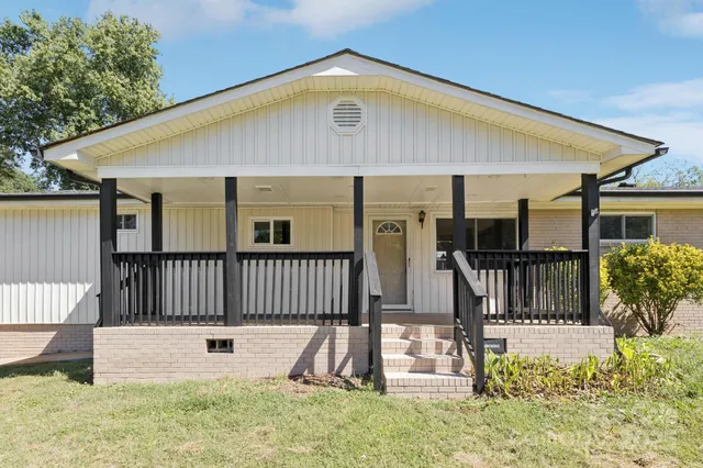 a view of a house with wooden fence and a porch