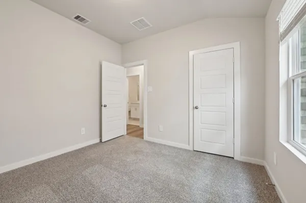an empty room with windows and closet