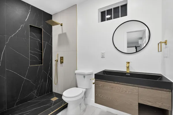 a bathroom with a sink a toilet and a mirror