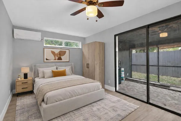 a bedroom with a large bed and a chandelier fan