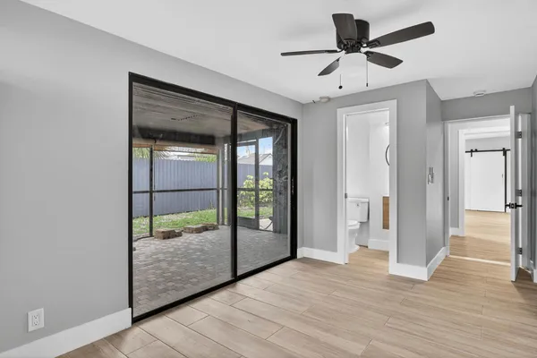 a view of a room with wooden floor and a ceiling fan