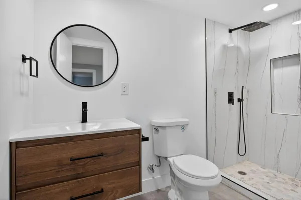 a bathroom with a sink a toilet and a mirror