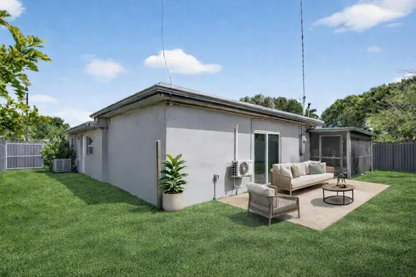 a backyard of a house with table and chairs