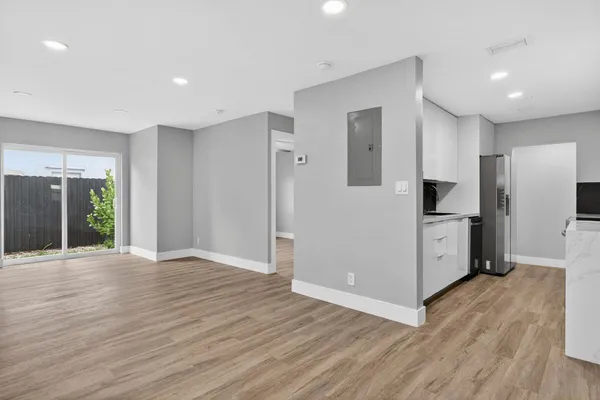 a view of a kitchen with wooden floor and electronic appliances