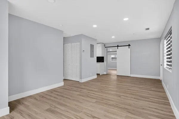 a view of empty room with wooden floor and window