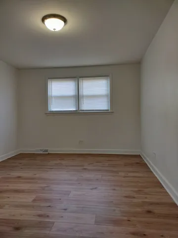 a view of a room with wooden floor and window