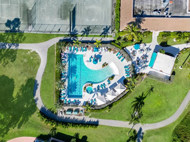 an aerial view of a swimming pool with outdoor seating