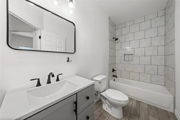 an empty room with chandelier fan and windows