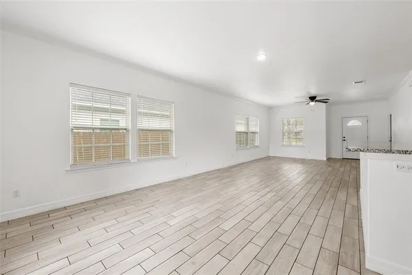 a view of a room with wooden floor and windows