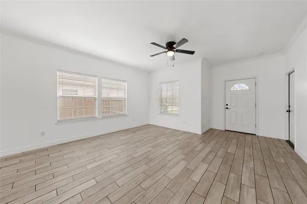 an empty room with wooden floor and windows