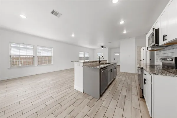 a kitchen with stainless steel appliances granite countertop a sink and stove
