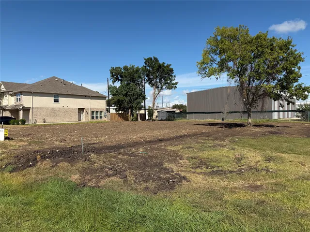 a backyard of a house with table and chairs under an umbrella