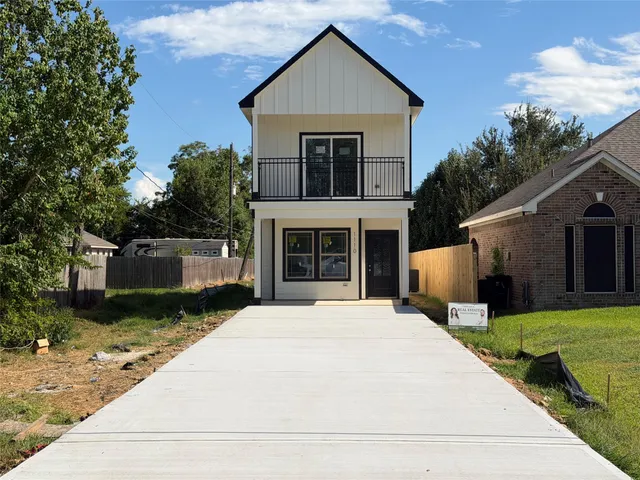 a front view of house with yard and trees in the background