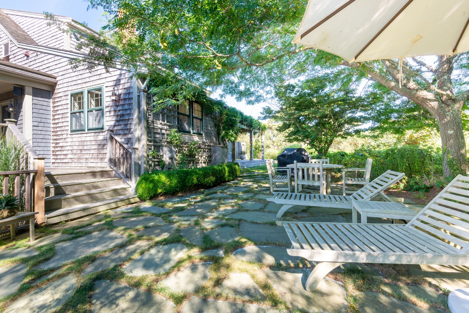 26 Pocomo Road Nantucket, MA 02554 - Photo 32 of 43 a view of a patio with a table and chairs and potted plants