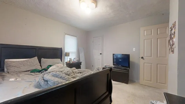 a bedroom with a bed and a refrigerator