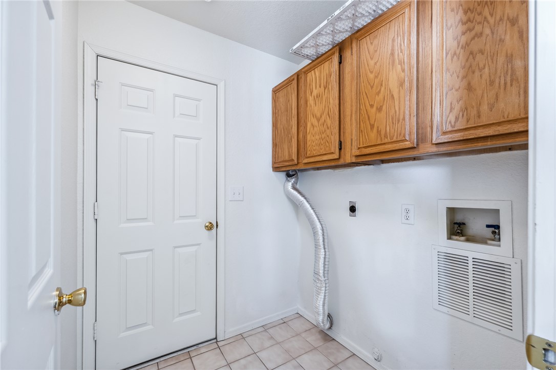 2524 South Ridge Avenue Bullhead City, AZ 86429 - Photo 46 of 64 Washroom featuring cabinet space, hookup for an electric dryer, washer hookup, baseboards, and light tile patterned floors