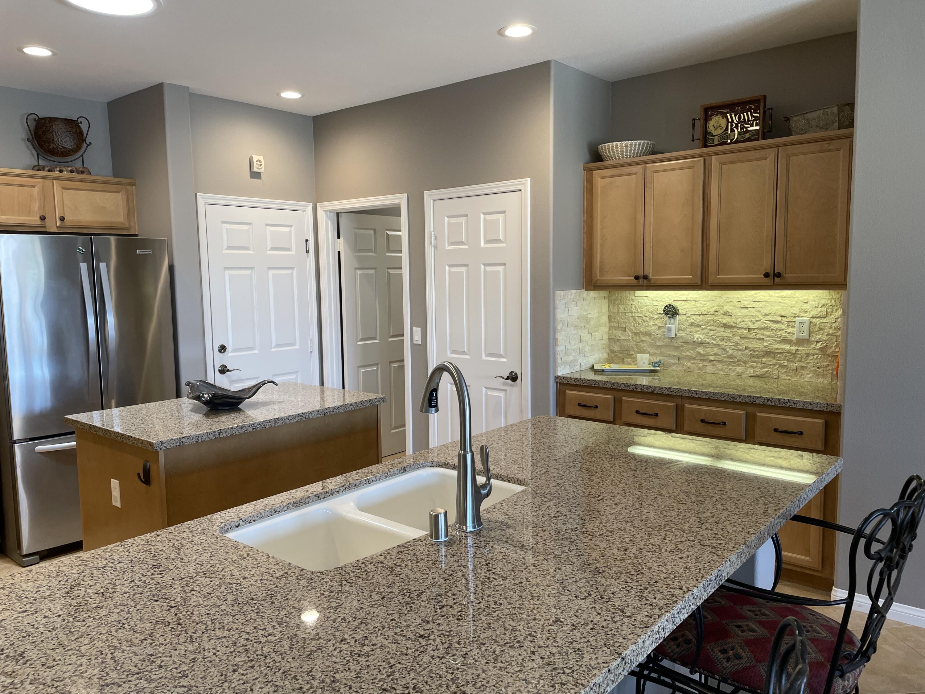 60880 Azul Court La Quinta, CA 92253 - Photo 11 of 33 a kitchen with kitchen island granite countertop a sink and refrigerator