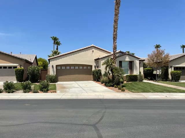 a front view of a house with a yard and potted plants
