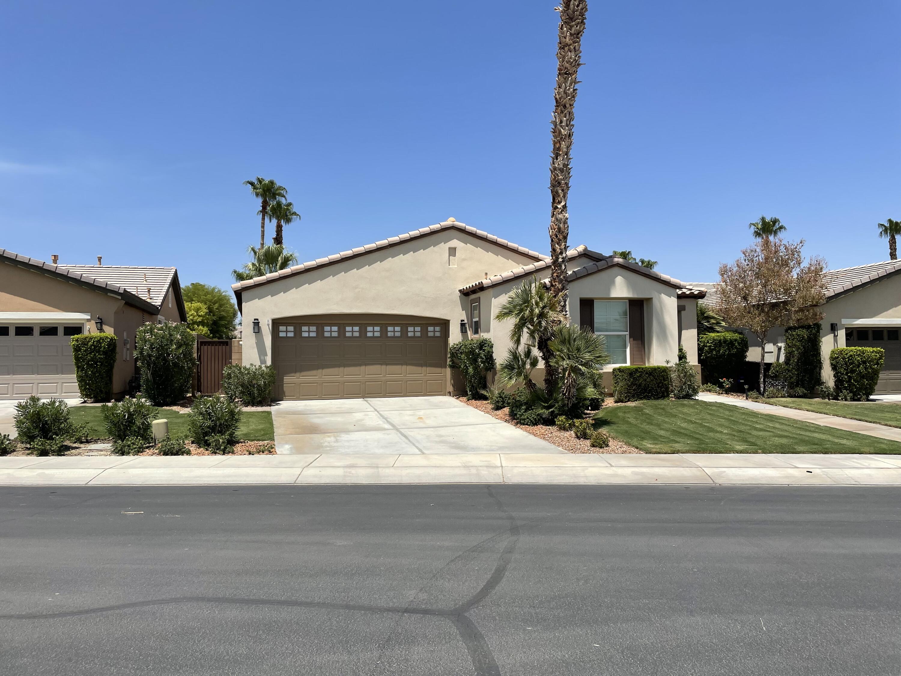 60880 Azul Court La Quinta, CA 92253 - Photo 29 of 33 a front view of a house with a yard and potted plants