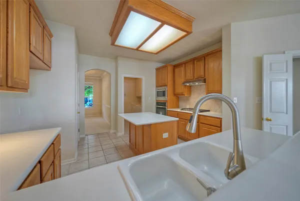 a kitchen with sink a refrigerator and couches