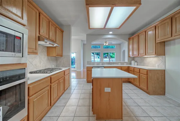 a kitchen with stainless steel appliances granite countertop a sink counter space cabinets and a stove
