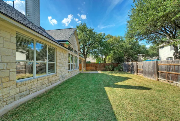 a view of a house with backyard and a tree