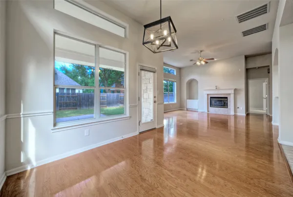 a view of a livingroom with furniture wooden floor windows and a fireplace