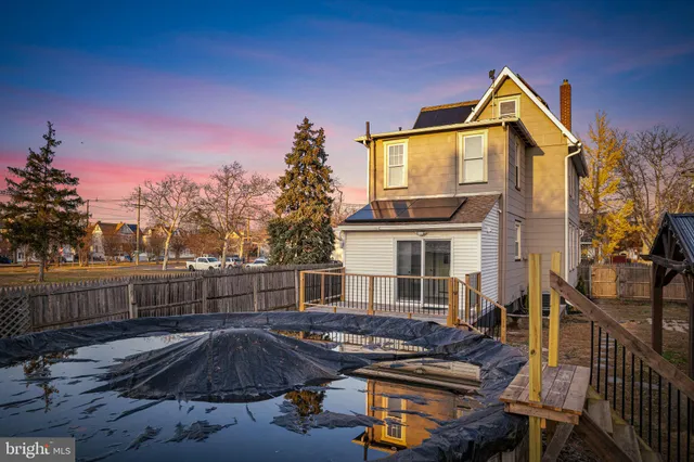 a view of backyard with deck and outdoor seating