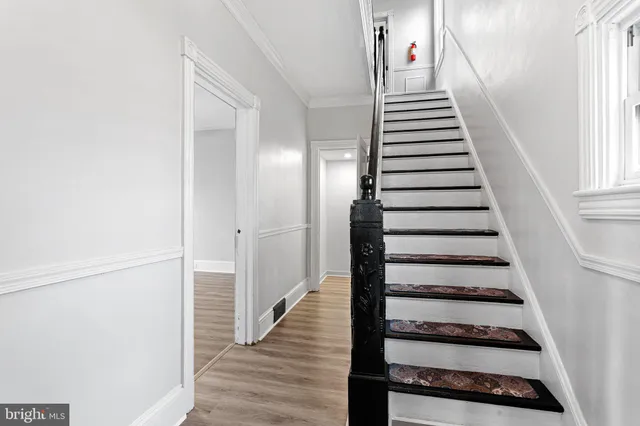 a view of a hallway with wooden floor and staircase