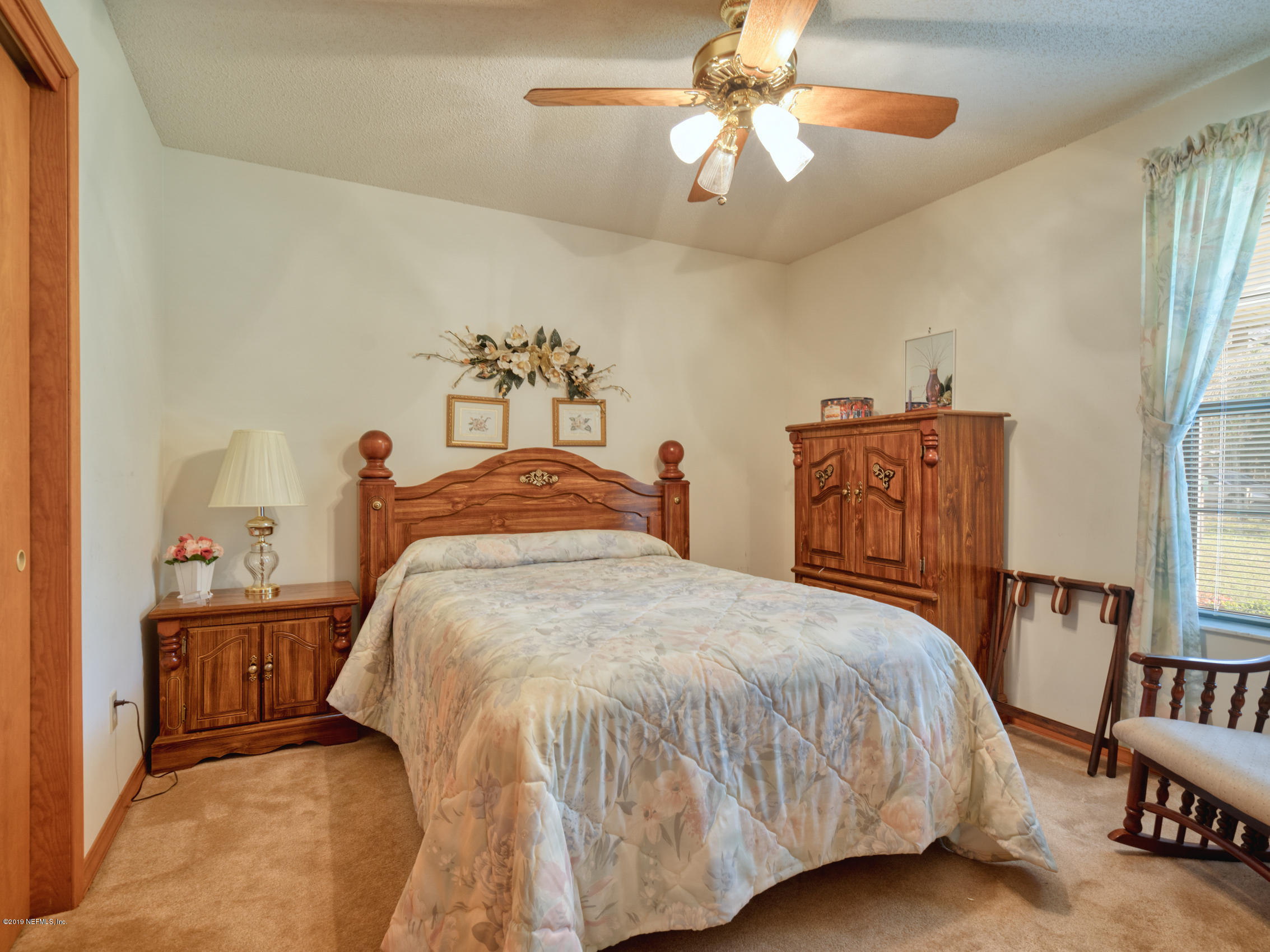 54814 Ogilvie Road Callahan, FL 32011 - Photo 15 of 30 a bedroom with a bed and a chandelier