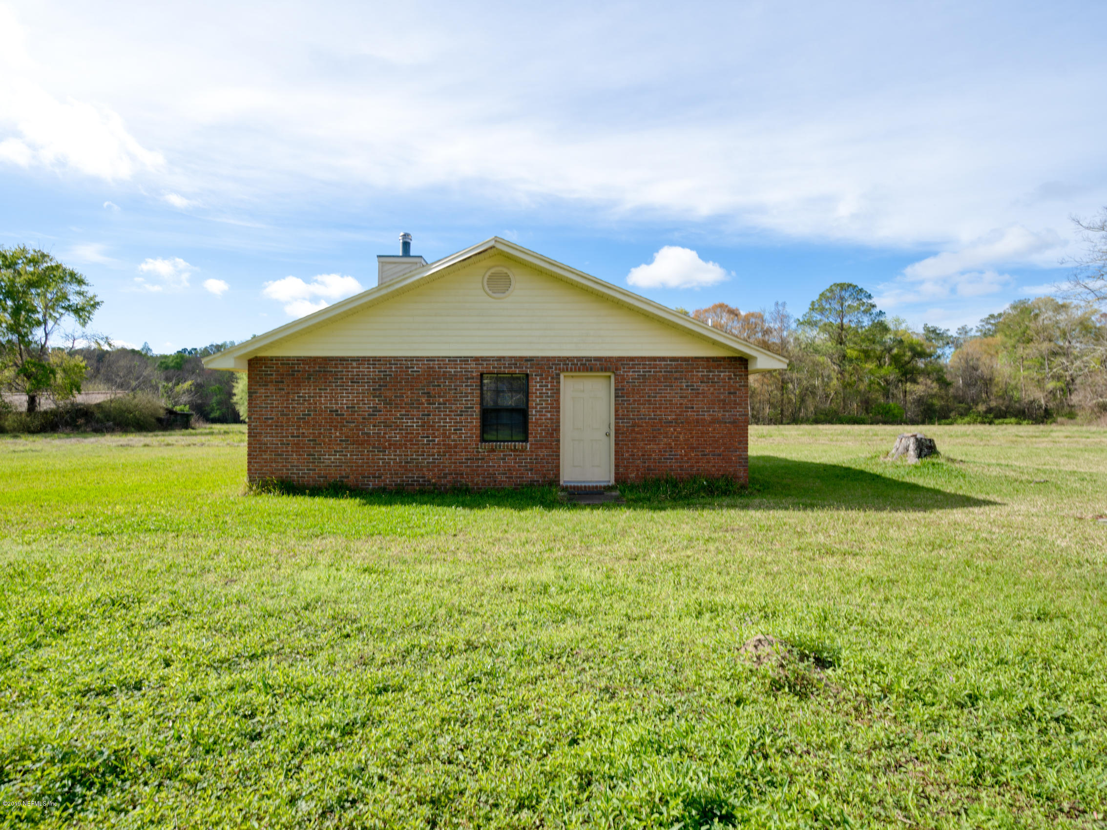 54814 Ogilvie Road Callahan, FL 32011 - Photo 23 of 30 a backyard of a house with lots of green space and garden