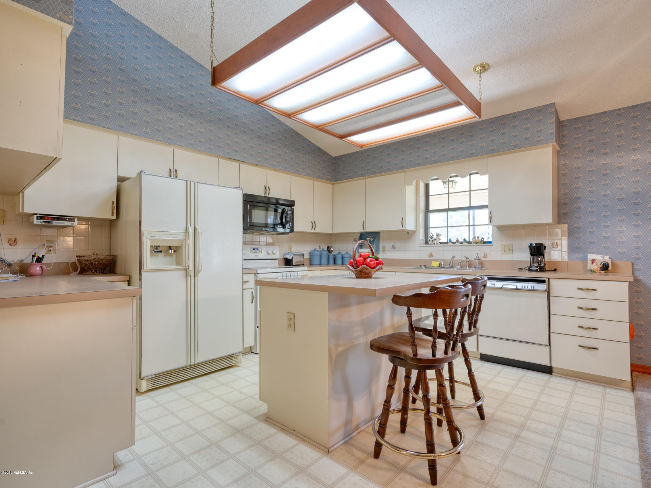 54814 Ogilvie Road Callahan, FL 32011 - Photo 6 of 30 a kitchen with white cabinets and stainless steel appliances