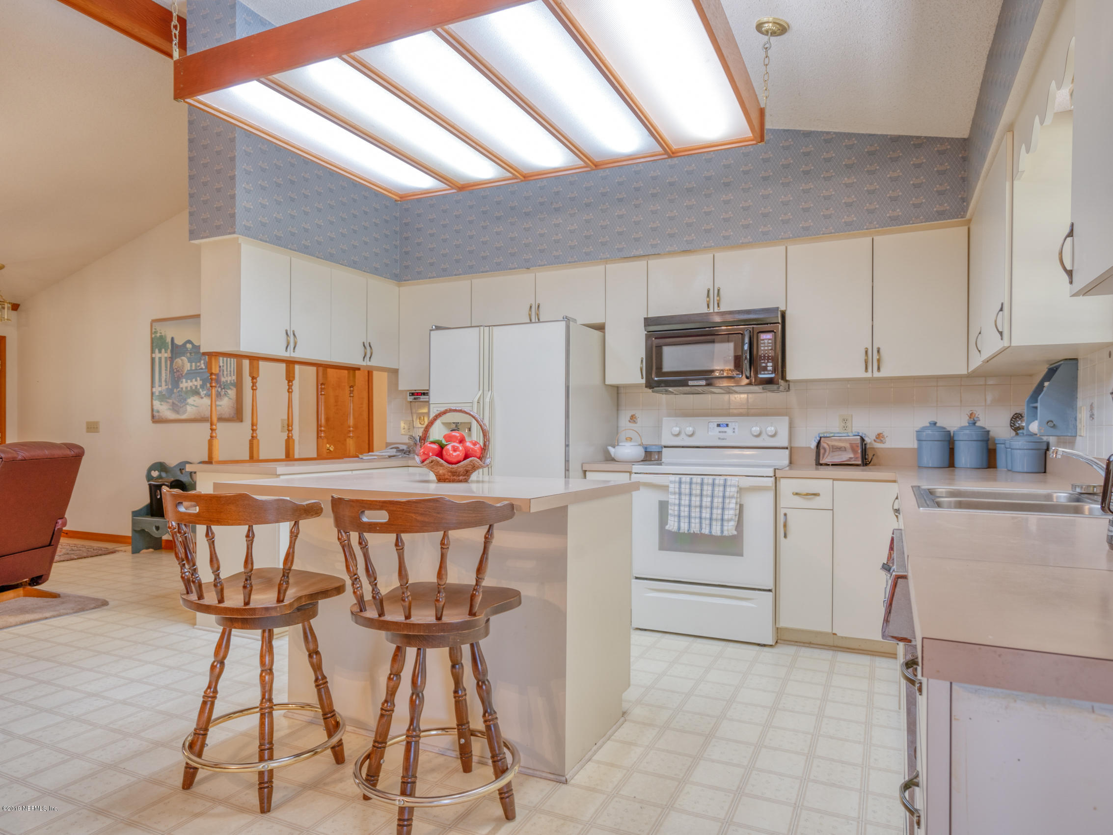 54814 Ogilvie Road Callahan, FL 32011 - Photo 7 of 30 a kitchen with a table chairs a microwave and cabinets