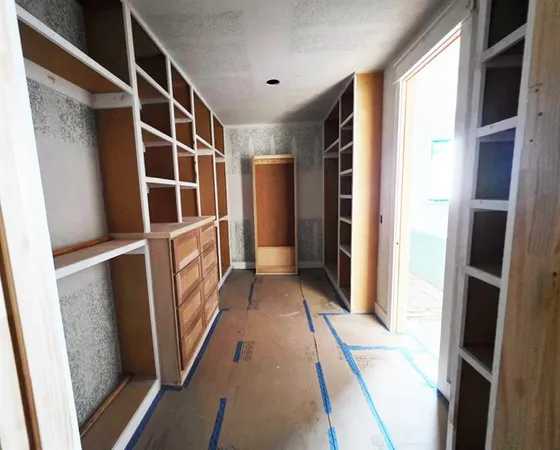 a view of walk in closet with empty racks