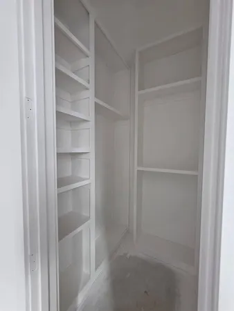 a view of walk in closet with empty racks