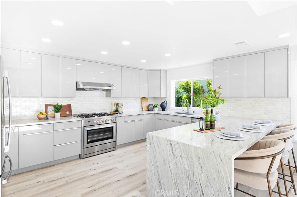 39 Cape Cod Irvine, CA 92620 - Photo 20 of 56 a kitchen with granite countertop kitchen island white cabinets and appliances