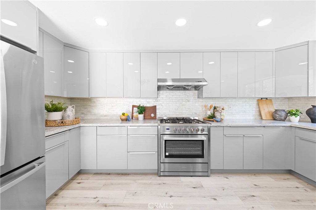 39 Cape Cod Irvine, CA 92620 - Photo 21 of 56 a kitchen with stainless steel appliances granite countertop a stove a sink and white cabinets