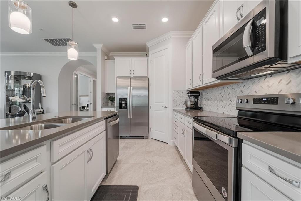 19855 Beverly Park Road Estero, FL 33928 - Photo 1 of 42 a kitchen with stainless steel appliances granite countertop a stove a sink and a microwave