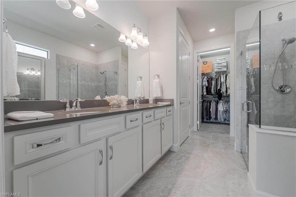 19855 Beverly Park Road Estero, FL 33928 - Photo 10 of 42 a spacious bathroom with a granite countertop sink a shower and a mirror