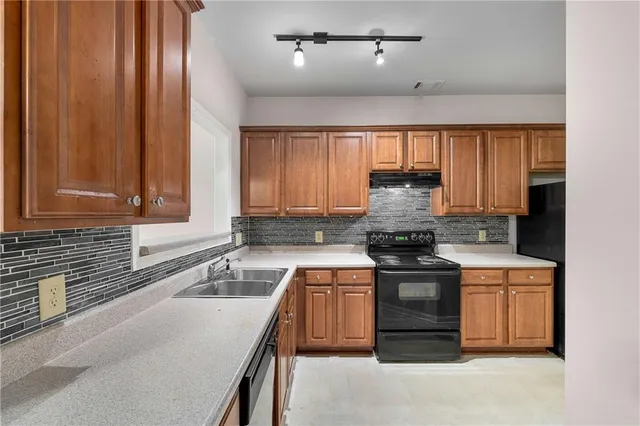 a kitchen with granite countertop a sink stove and cabinets