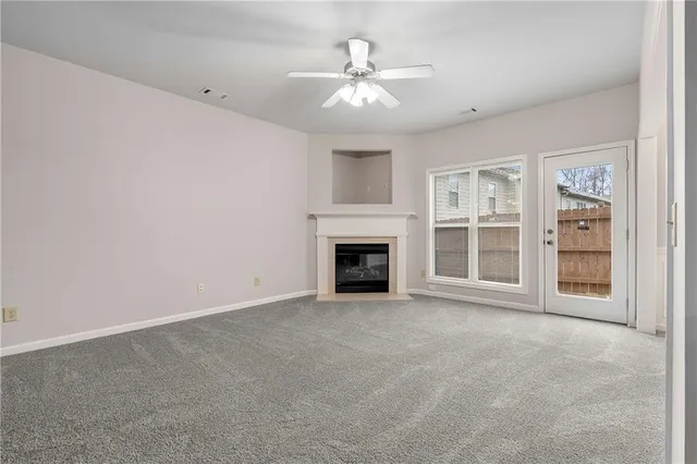 a view of an empty room with a fireplace and a window
