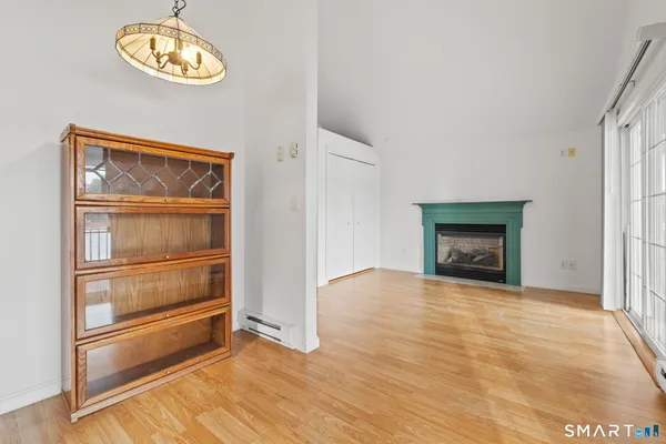 a view of an empty room with a fireplace and a window