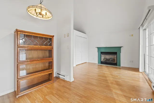 a view of an empty room with a fireplace and a window